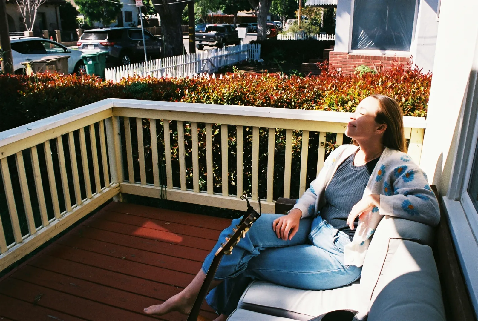 A woman resting on a sunlit porch, feet up, unhurried